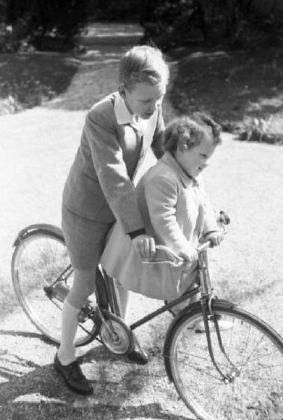 Roma. Quirinale - esterno. Il principe Vittorio Emanuele in bicicletta porta Maria Beatrice di Savoia seduta in canna