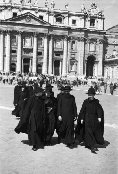 Roma. Piazza San Pietro. Gruppo di preti attraversa la piazza. Sullo sfondo la basilica
