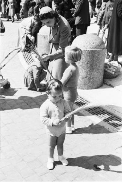 Roma. Piazza San Pietro. Un bambino osserva le foglie di palma; alle sue spalle una folla di pellegrini raccolta nella piazza