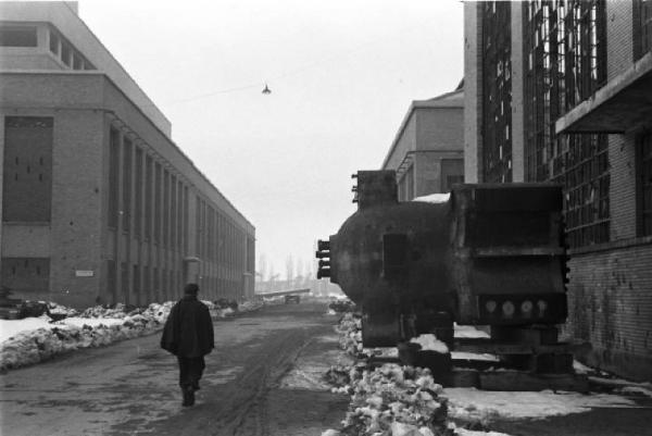 Italia Dopoguerra. Torino. Stabilimento Fiat Mirafiori. Operaio percorre una strada tra gruppi di edifici del complesso industriale