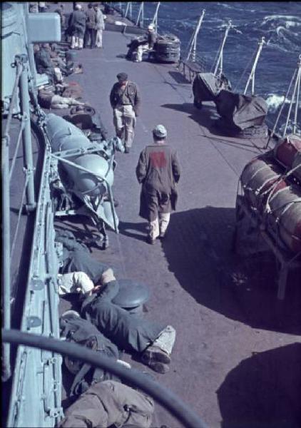 Italia Dopoguerra. Missione Casablanca. Ex prigionieri italiani sul ponte del cacciatorpediniere Duca degli Abruzzi. Uno di essi reca, cucita sulla schiena, una pezza con la scritta PG [prigioniero di guerra?]. A lato le onde dell'Oceano Atlantico