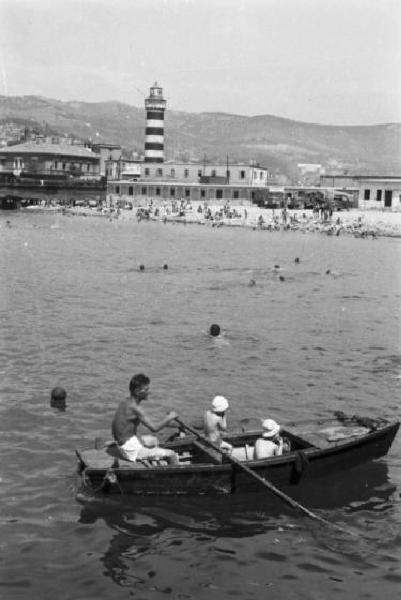 Italia Dopoguerra. Trieste - La città vista dal golfo - In primo piano una famiglia su una imbarcazione a remi