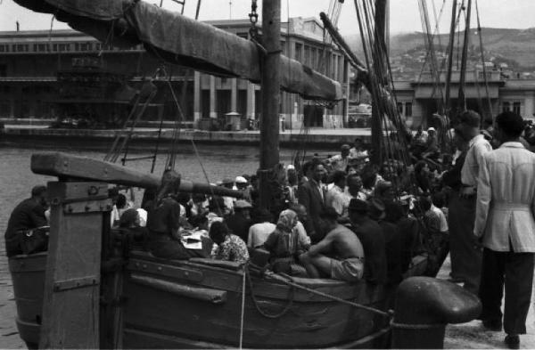 Italia Dopoguerra. Porto di Trieste. Una imbarcazione carica di persone ormeggiata in banchina