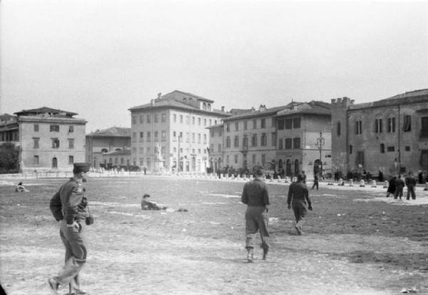 Pisa. Campo dei Miracoli. Militari in libera uscita passeggiano sul prato. Uno di essi ha appesa al collo una macchina fotografica