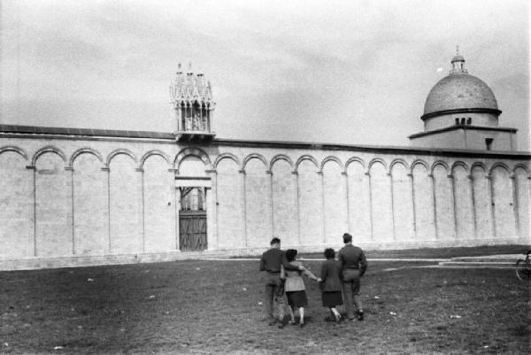 Pisa. Campo dei Miracoli. Due militari e due ragazze passeggiano in direzione del muro del camposanto