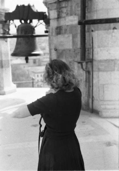 Pisa. Campo dei Miracoli. Giovane donna si affaccia dalla torre campanaria pendente