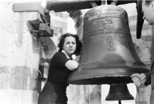Pisa. Giovane donna appoggiata alla campana della torre pendente