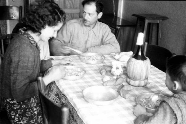 Italia Dopoguerra. Quartiere Baggio a Milano. Famiglia riunita a tavola per la cena