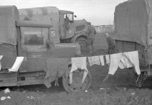 Campagna di Russia. Ucraina - Slavianka [?] - panni stesi tra due automezzi militari