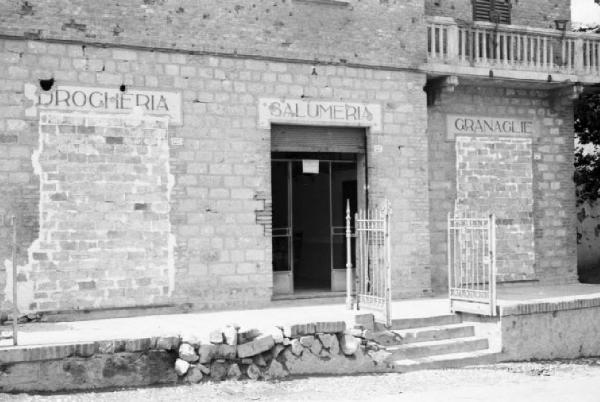 Italia Dopoguerra. Marzabotto - Il paese devastato, la porta murata della drogheria e l'ingresso della salumeria
