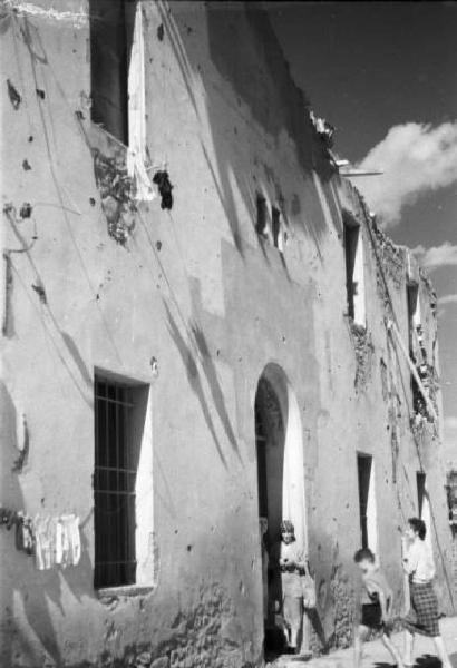 Italia Dopoguerra. Marzabotto - Il paese devastato, un edificio con la facciata crivellata di colpi