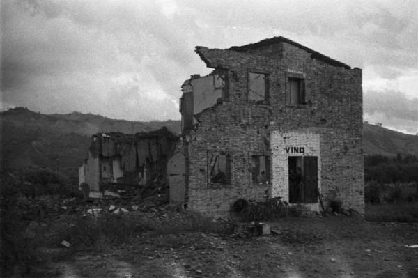 Italia Dopoguerra. Marzabotto - Un edificio semidistrutto con rivendita di vino