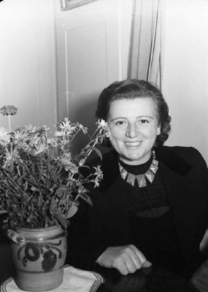 Ritratto femminile - donna sorridente seduta accanto a un vaso di fiori - Olga Delagrange (?)