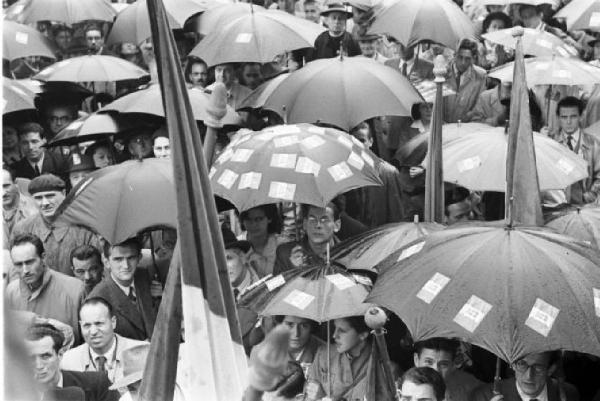 Referendum 1946 Repubblica o Monarchia. Milano - Piazza del Cannone - Manifestazione monarchica - Folla riparata sotto ombrelli con adesivi della bandiera monarchica