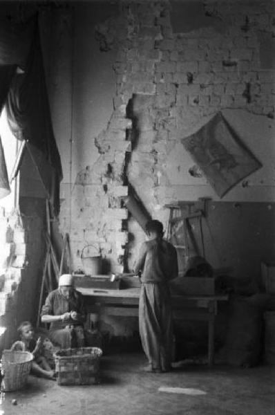 Italia Dopoguerra. Marzabotto - Famiglia alloggiata all'interno di un edificio parzialmente distrutto dai bombardamenti