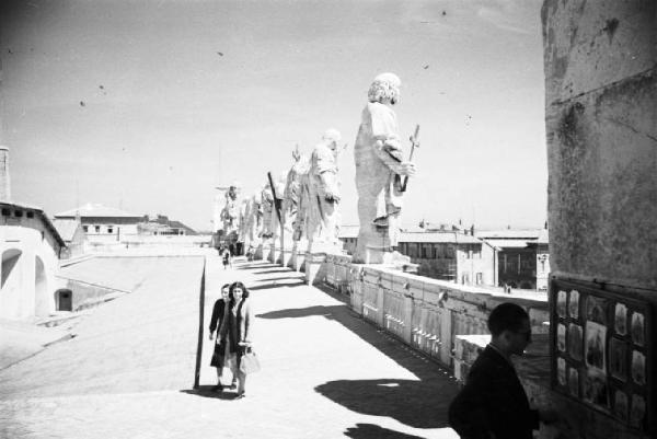 Roma. Piazza S. Pietro. Due persone sulla copertura del colonnato del Bernini, con statue in evidenza