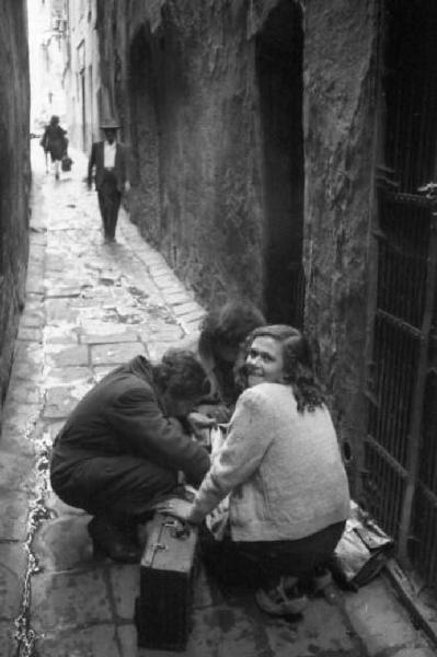 Italia Dopoguerra. Genova - Caruggio - tre ragazze accovacciate