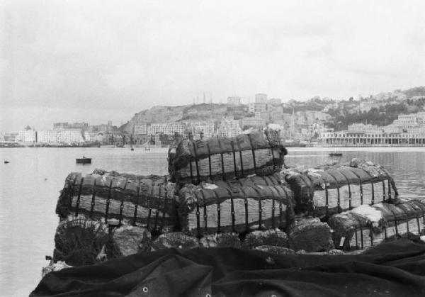 Italia Dopoguerra. Genova - Scorcio di una barca in mare con un carico di cotone - Sullo sfondo la città