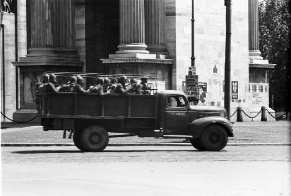 Italia Dopoguerra. Milano. Mezzo militare con soldati di passaggio presso l'Arco della Pace - insegne stradali in lingua inglese