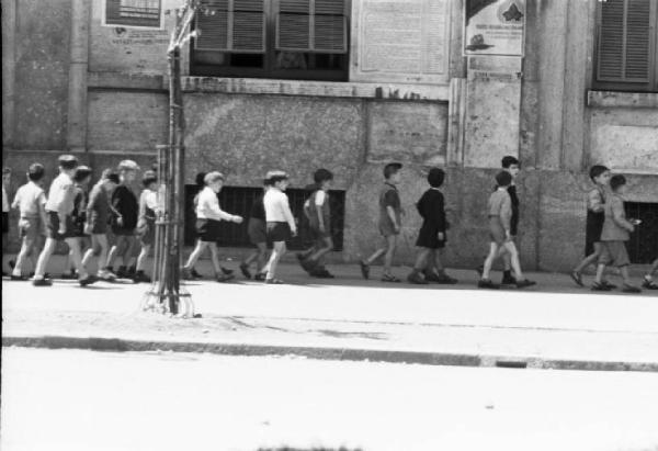 Italia Dopoguerra. Milano. Bambini camminano in fila lungo il marciapiede