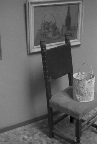 Roma. Palazzo delle Esposizioni. IV Quadriennale. Allestimento mostra - sedia con un secchio di pittura accanto a un quadro appeso alla parete