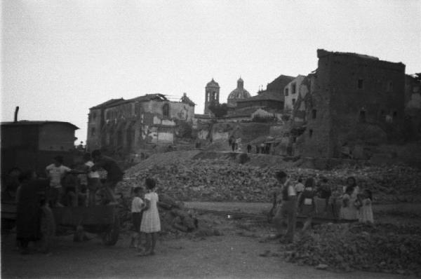 Italia Dopoguerra. Viterbo - Edifici distrutti dopo i bombardamenti - Sulla sinistra bambini che giocano su una carro