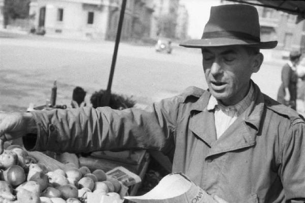 Italia Dopoguerra. Milano. Vendita al mercato di prodotti a prezzi calmierati. Primo piano di un venditore di pere