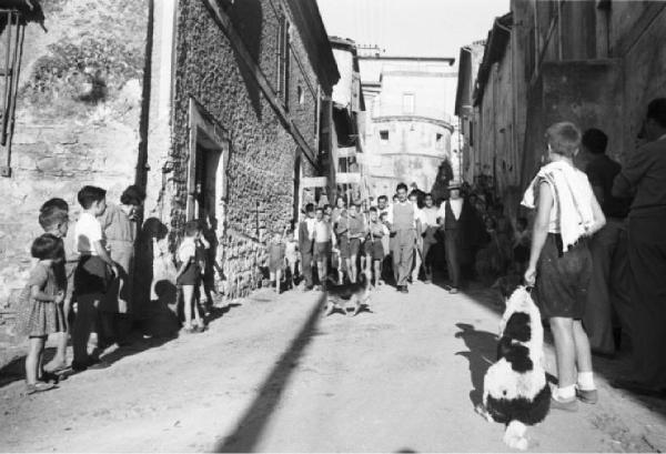 Invasione delle terre. Gruppo di contadini e bambini con cartelli marciano in un vicolo