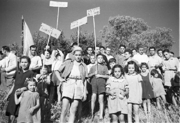 Invasione delle terre. Contadini che manifestano. I bambini in primo piano tengono in mano cartelli di protesta