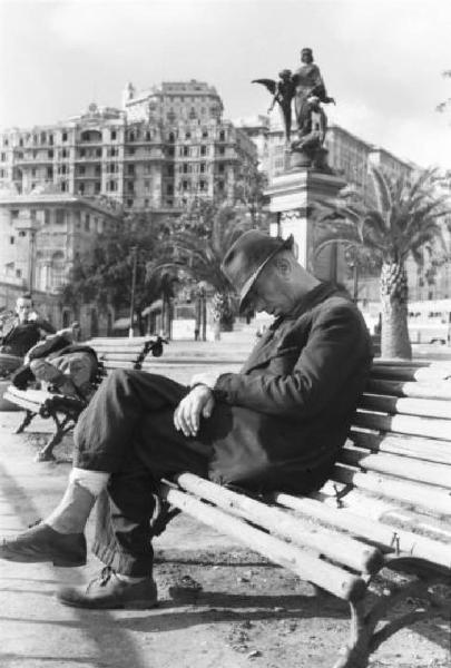 Italia Dopoguerra. Genova - Uomo che dorme sulla panchina di una piazza della città