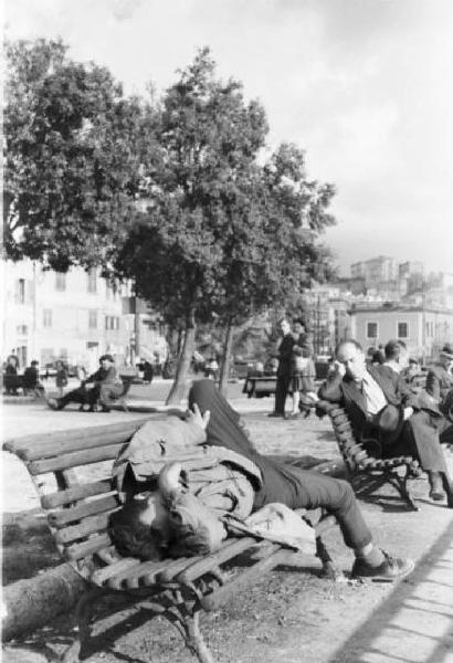 Italia Dopoguerra. Genova - Alcuni uomini si riposano dormendo sulle panchine dei giardini pubblici