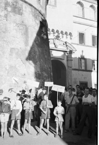 Invasione delle terre. Gruppo di contadini manifesta nei vicoli di Castelgandolfo. In primo piano bambini reggono cartelli di protesta