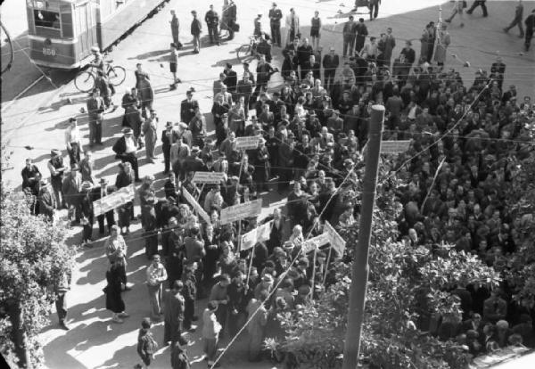 Italia Dopoguerra. Genova - Manifestazione di marittimi - folla di persone con cartelli radunata in una piazza della città