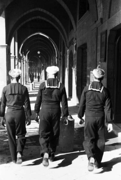 Italia Dopoguerra. Genova - Gruppo di marinai passeggia sotto il portico di un edificio in città