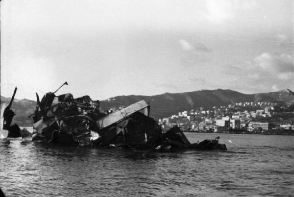 Italia Dopoguerra. Genova - Porto - veduta della costa con relitti di navi in primo piano