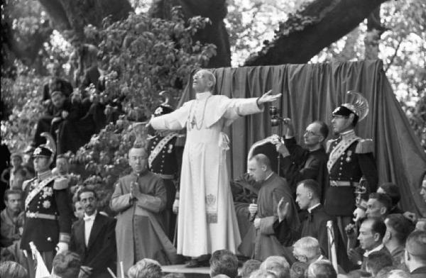 Ike a Castel Gandolfo. Il Papa Pio XII in una posa da invocazione, mentre parla a una platea di giovani da un pulpito all'aperto