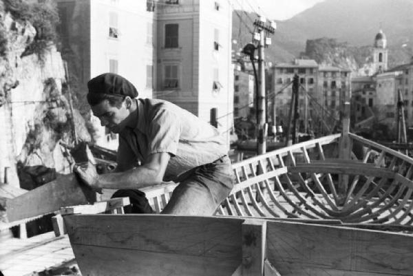 Italia Dopoguerra. Camogli - Porto - carpentiere al lavoro nella costruzione di una barca