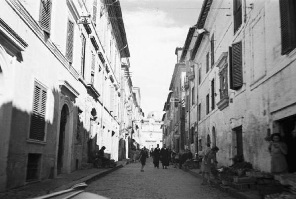 Ike a Castel Gandolfo. Via del centro con persone che passeggiano. Si notano due suore