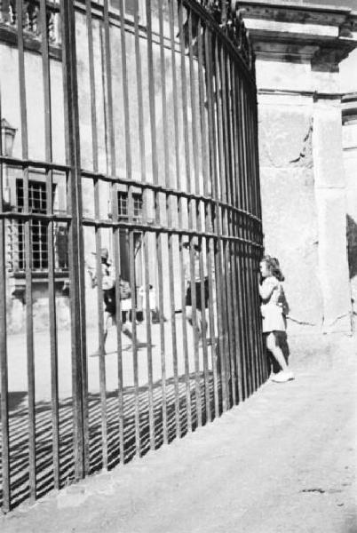 Ike a Castel Gandolfo. Bambina aggrappata a una cancellata dietro alla quale si intravvede uno scout
