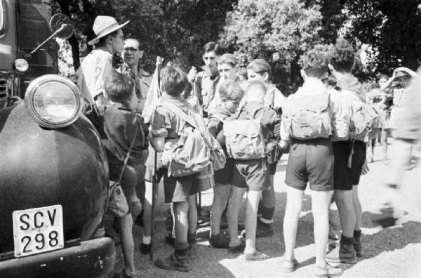 Ike a Castel Gandolfo. Gruppo di giovani scout appoggiati alla carrozzeria di un camion