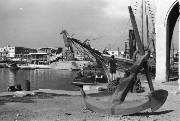 Italia Dopoguerra. Genova - Scorcio del porto - in primo piano un'ancora appoggiata lungo la banchina