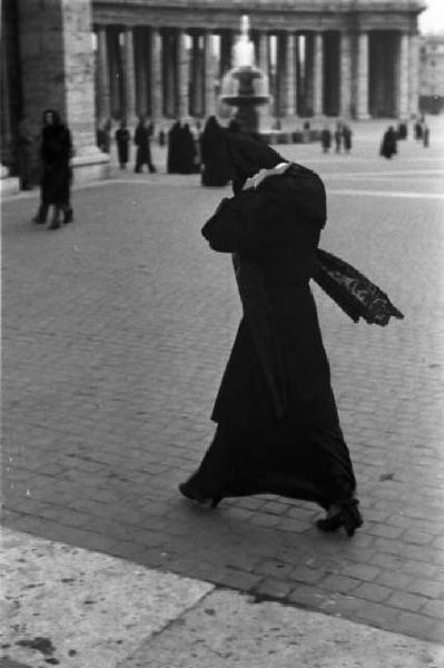Roma. Piazza San Pietro. Una donna con il capo ricoperto da un mantello attraversa la piazza