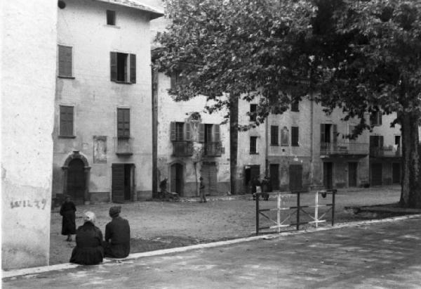 Gera Lario - Bill e Pedro - ricostruzione dell'uccisione di Benito Mussolini - Scorcio dell'abitato con una coppia di signore sorpresa di spalle seduta sopra un muretto