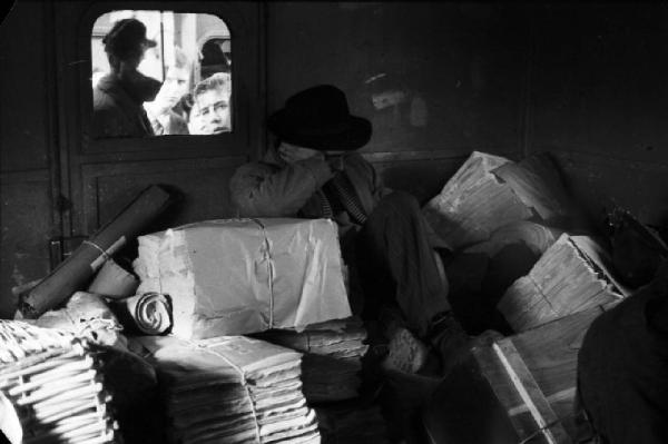 Stazione ferroviaria di Piacenza - Un uomo dorme accovacciato nella sala di aspetto