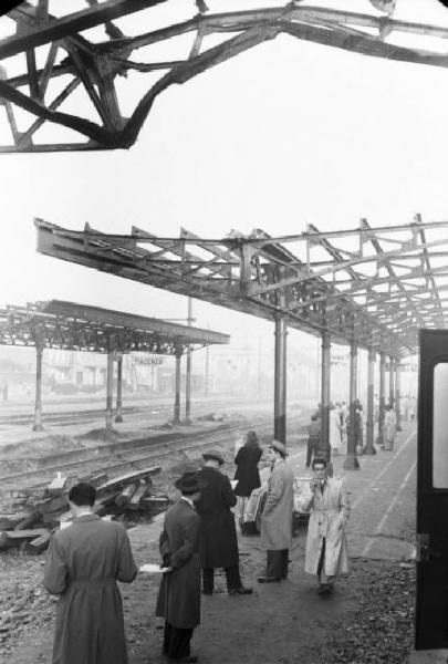 Stazione ferroviaria di Piacenza - scorcio della pensilina sui binari con i viaggiatori in attesa