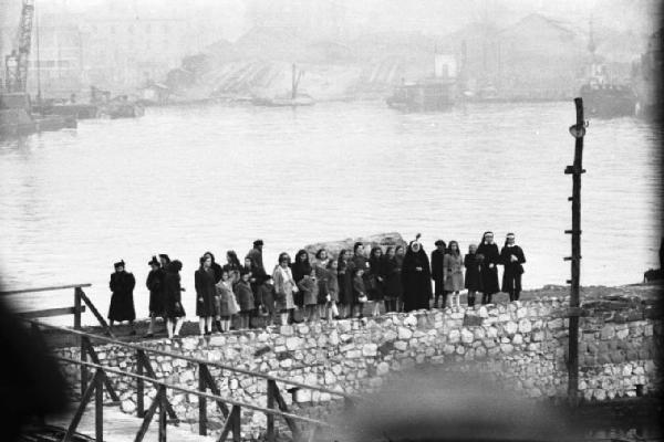 Missione Casablanca. Napoli. Donne, ragazze, bambine e suore lungo un molo in attesa dello sbarco degli ex prigionieri dal cacciatorpediniere Duce degli Abruzzi