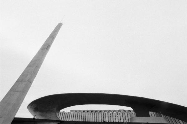Brasilia. Ripresa dal basso di un cornicione curvo in cemento e di un obelisco.che si staglia contro il cielo