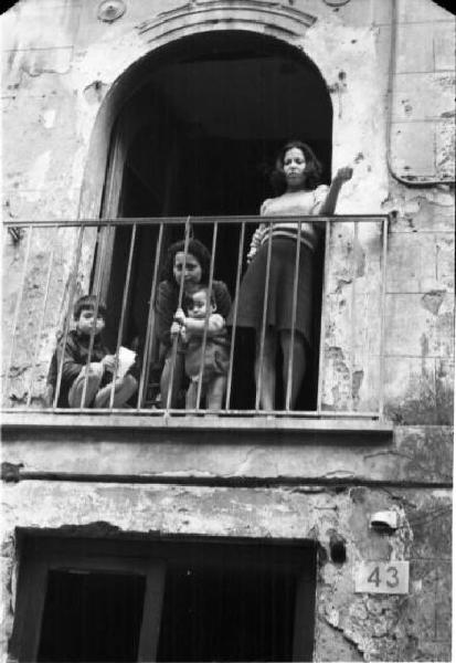 Italia Dopoguerra. Napoli. Due donne affacciate ad un balcone con due bambini