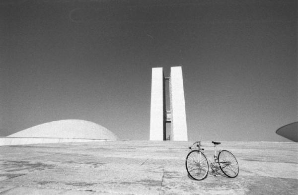 Brasilia. Bicicletta da corsa davanti alle due cupole e ai due grattacieli del Congresso Nazionale