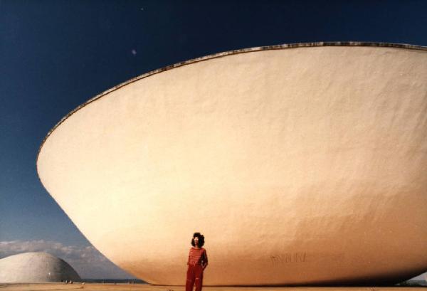 Brasilia. Figura femminile (Cyssa) davanti a una cupola del Congresso Nazionale, con l'altra sullo sfondo